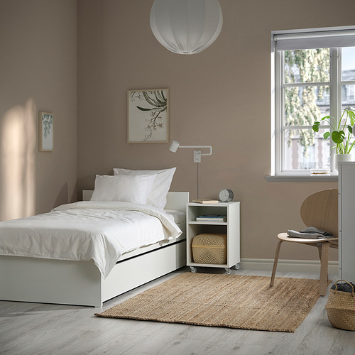 Dormitorio moderno con cama VIHALS blanca, mesita de noche, taburete y gran ventanal.