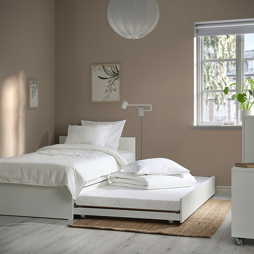 Dormitorio moderno y minimalista con sofá cama blanco VIHALS y nido. Grandes almohadas blancas, luz colgante, arte de pared y ventana con vista. Limpio y espacioso.