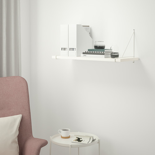 Disposición minimalista de estanterías y mesas con decoración.