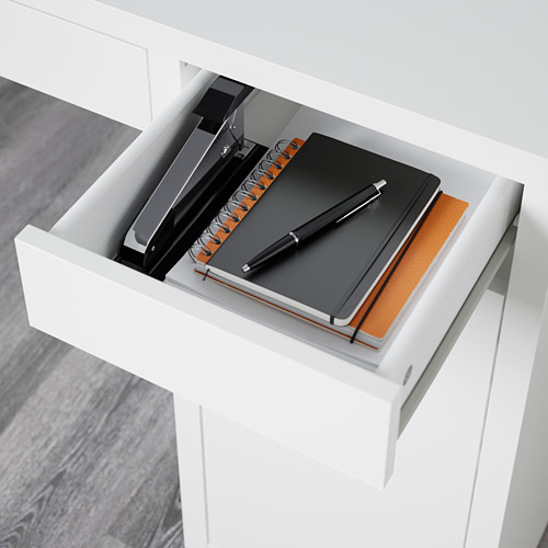 Cajón de escritorio blanco abierto con cuaderno, bolígrafo y carpeta que muestra la administración de cables y estantes ajustables.