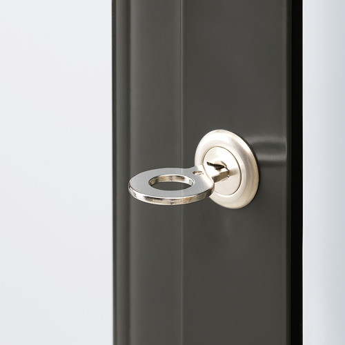 Primer plano de la elegante cerradura de puerta metálica en un elegante gabinete. Muestra el ojo de la cerradura plateado y la placa de bloqueo redonda.