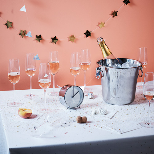 Copas de champán y cubitera sobre la mesa, decorada con guirnalda de estrellas.
