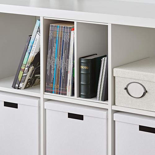 Estantería KALLAX blanca con insertos para revistas y libros, y cajas de almacenaje.