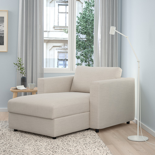 Moderna tumbona VIMLE beige. Grande, acogedor, con almacenaje. Al lado de una lámpara alta, bajo un gran ventanal. Tiene diseño de madera y tela.