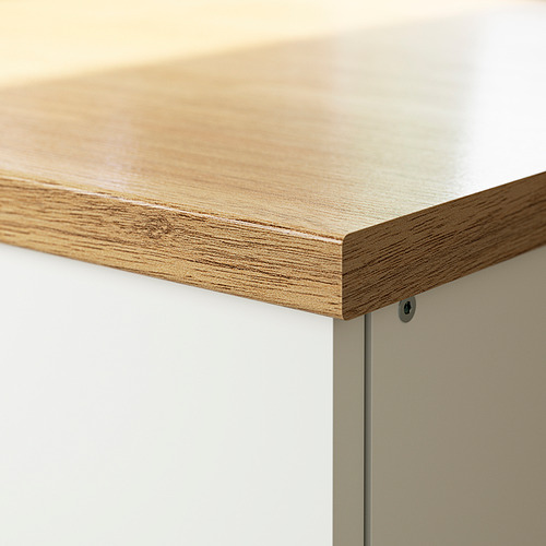 Encimera de cocina moderna con laminado de madera clara y bordes elegantes contra gabinetes blancos.