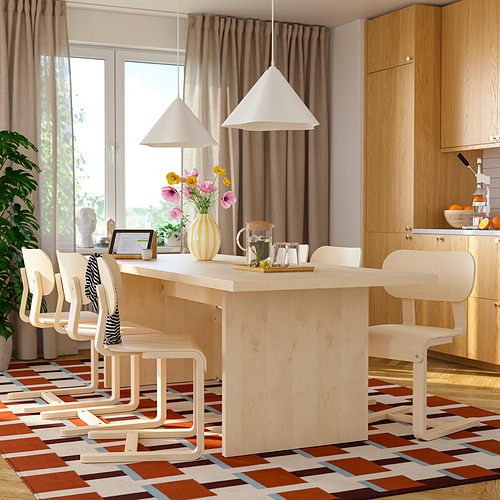 Comedor moderno con gran mesa de madera clara, seis sillas, alfombra y lámparas colgantes.