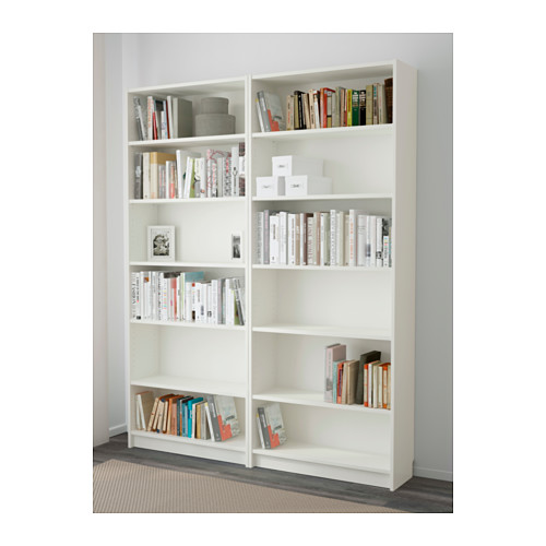 Estanterías blancas BILLY con estantes ajustables, que albergan diversos libros y artículos decorativos, ancladas de forma segura a la pared.