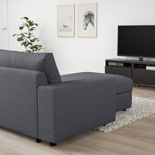 Moderno sofá modular VIMLE gris con almacenaje. Diseño elegante y minimalista. Acentuado con planta y tv. Suelo de madera.
