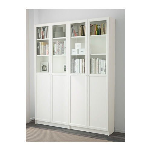 Librería blanca BILLY con puertas de cristal, expositora de libros en estanterías ajustables, ancladas a la pared.