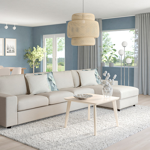 Sala de estar moderna con sofá VIMLE, mesa de centro, paredes azules, grandes ventanales y lámpara colgante tejida.
