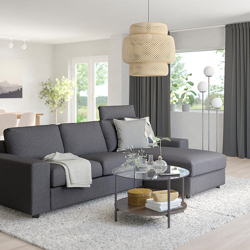 Elegante y moderna sala de estar con sofá gris VIMLE, mesa de centro de madera, lámpara colgante y gran ventana con cortinas oscuras. Secciones de sofás ajustables.