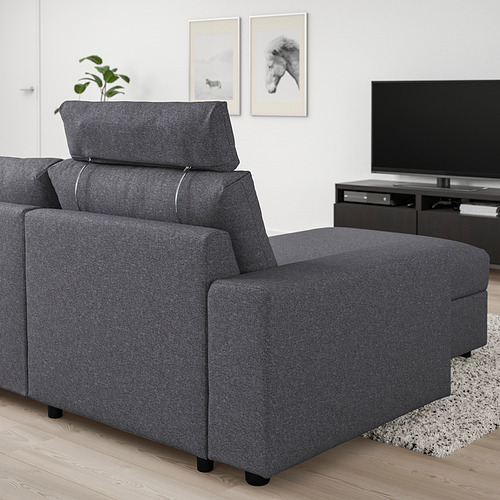 El sofá VIMLE en gris oscuro con reposacabezas ajustable y chaise longue, ubicado en una sala de estar con tv y alfombra.