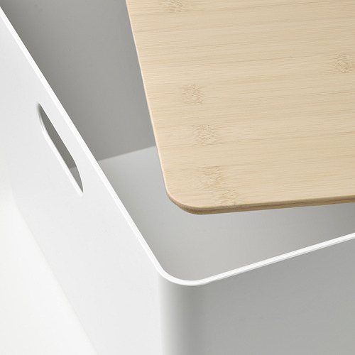 Primer plano de una caja de almacenamiento moderna con asa elegante y tapa de bambú.