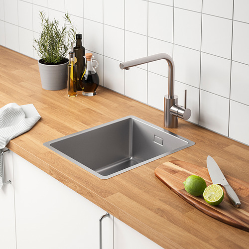 Fregadero de cocina moderno con grifo, cuchillos, limas y botellas.