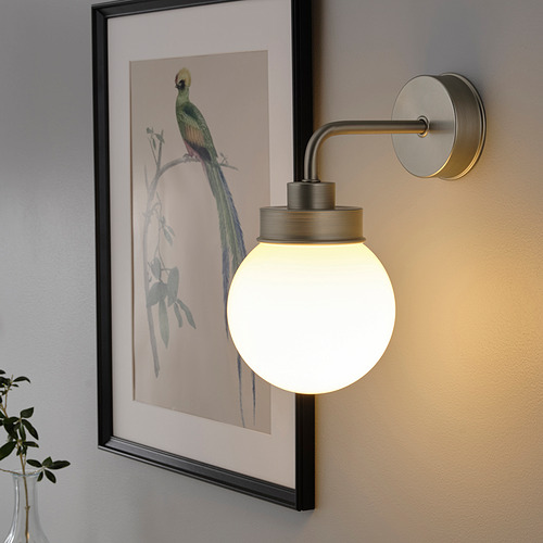 La lámpara de pared con pantalla de vidrio emite una luz cálida, perfecta para pasillos o baños.