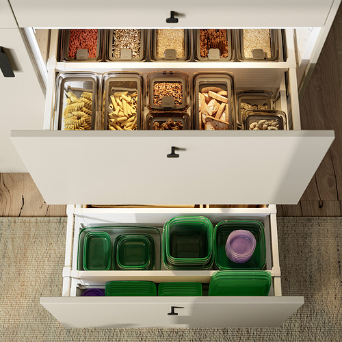 Mueble de cocina con tres estantes, cada uno de los cuales contiene recipientes de plástico transparente llenos de diferentes tipos de alimentos, organizados y almacenados.