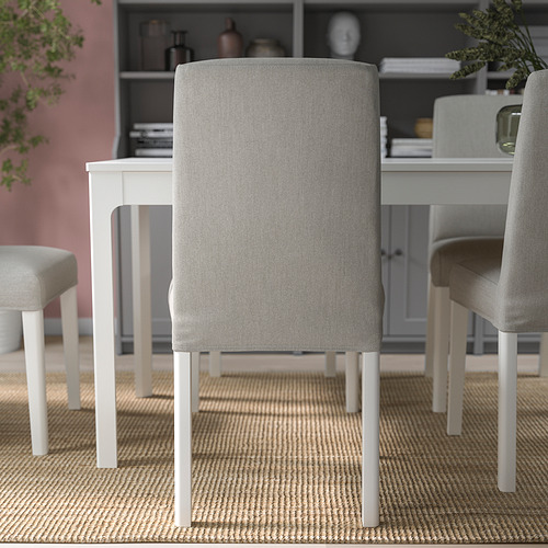 Moderna zona de comedor con sillas tapizadas en gris alrededor de una mesa blanca, con un cómodo respaldo y funda desenfundable.