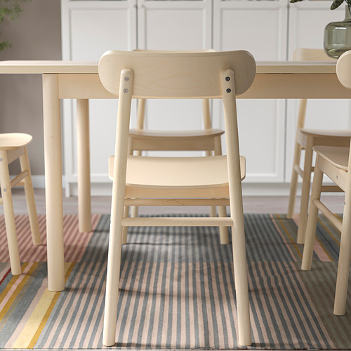 Silla de comedor de madera, diseño simple y robusto con vetas visibles, asiento y respaldo cómodos.