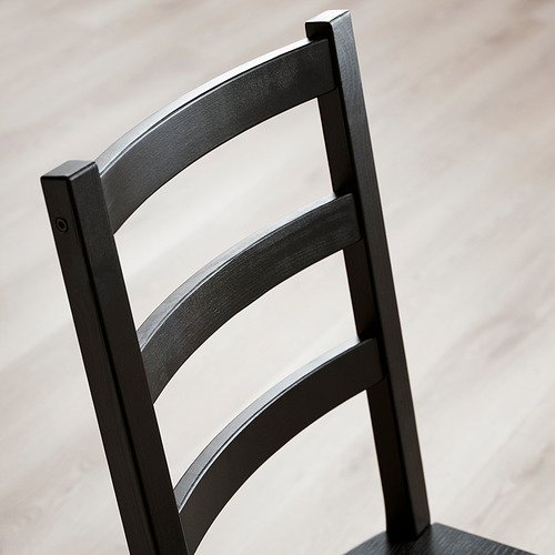 Silla de madera negra en primer plano, con un diseño elegante y una artesanía robusta.