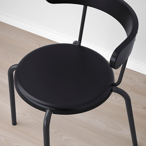 Silla negra moderna con diseño elegante, asiento y respaldo redondos, patas metálicas resistentes, perfecta para espacios contemporáneos.