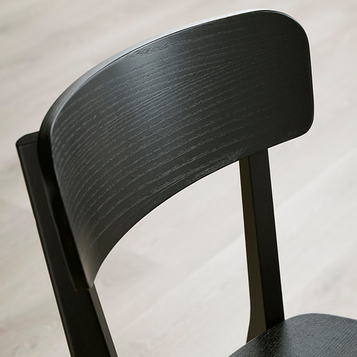 Respaldo de silla de madera negra, elaborado con fresno liso chapado, con un diseño robusto y elegante en una decoración moderna.