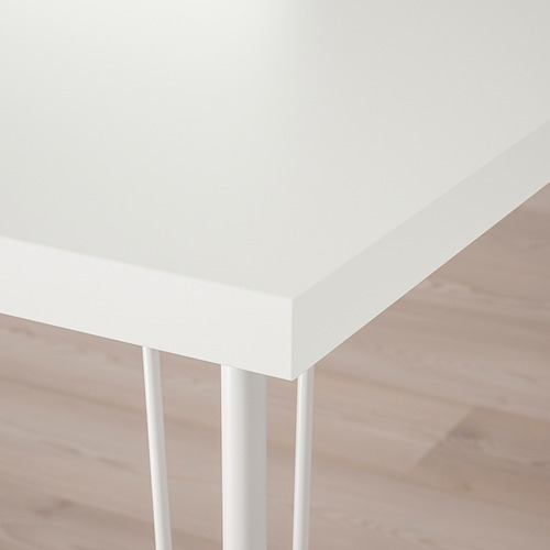 Un rincón de mesa blanco y nítido con elegantes patas de metal, que muestra un diseño moderno y minimalista.