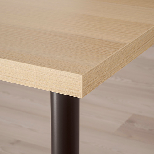 Primer plano de un tablero de madera moderno y bien acabado con elegantes patas de metal, que muestra su diseño robusto y minimalista.