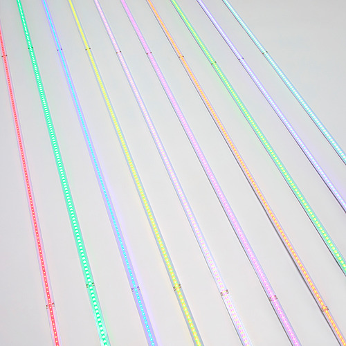 Tiras de luz LED de colores con conectores usb, que muestran múltiples colores y patrones, dispuestos en diagonal sobre un fondo claro.