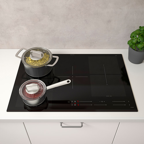 Cocina moderna con placa de inducción negra para cocinar dos ollas. Controles digitales, planta a la derecha.