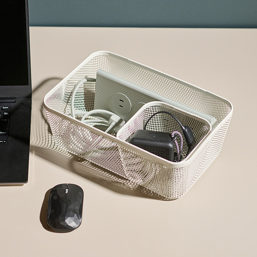 Bandeja de almacenamiento de malla en el escritorio con accesorios tecnológicos, incluido un concentrador USB y cables, junto a una computadora y un mouse.