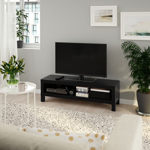 Moderno mueble de tv LACK con pantalla plana, almacenamiento abierto, cama, taza de café, plantas, impresiones artísticas, ventana grande.