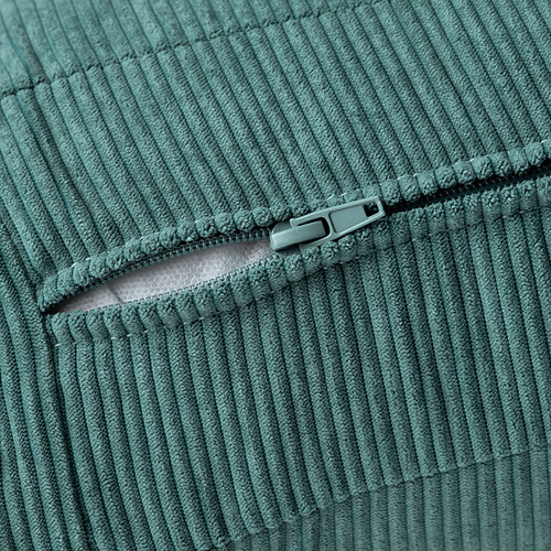 Sofá con textura verde azulado con cremallera central, que muestra tapicería de calidad y detalles de diseño.