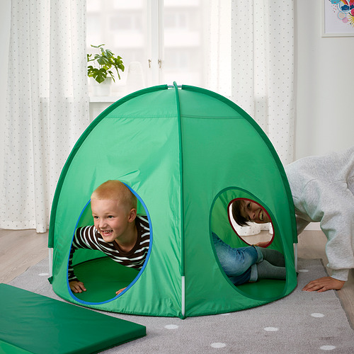 Dos niños juegan dentro de una carpa pop-up verde, disfrutando de su espacio privado con ventanas circulares.