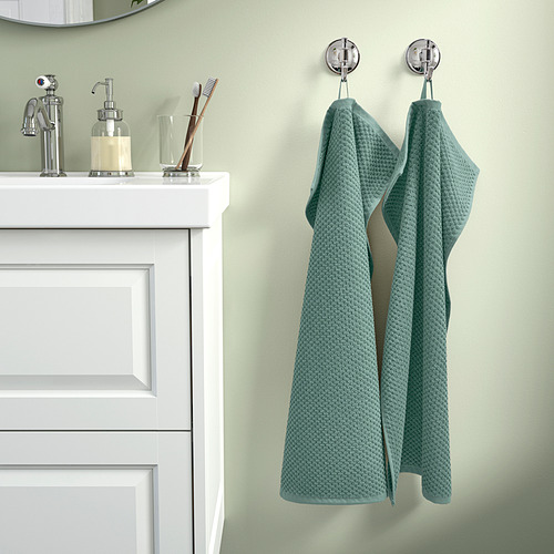 Baño con armario blanco, toallas GULVIAL, accesorios metálicos.
