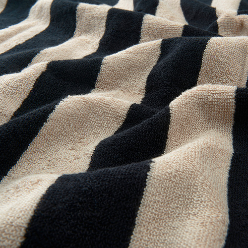 Toalla suave a rayas con estampados negros y beige, con textura de alta calidad.