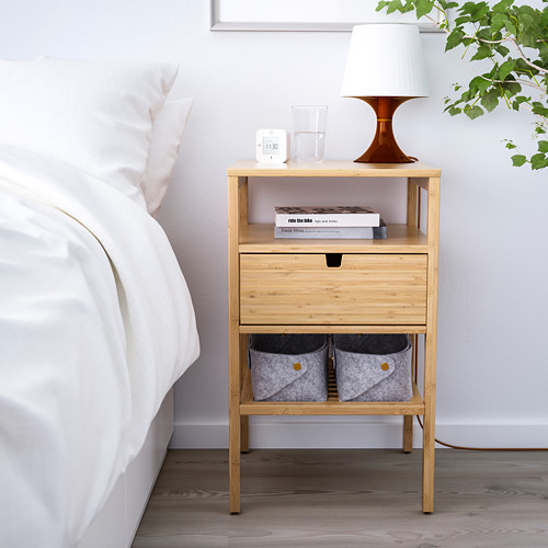 Mesita de noche de bambú NORDKISA. Pequeño, al lado de la cama. Sostiene lámpara, libros y plantas. Madera clara, diseño sencillo.