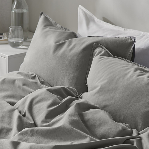 Cama con edredón nórdico de algodón gris, liso y acogedor.