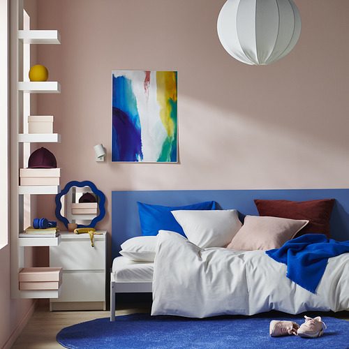 Dormitorio moderno: cama azul con fundas blancas, paredes rosas; Pintura abstracta, estanterías abiertas.