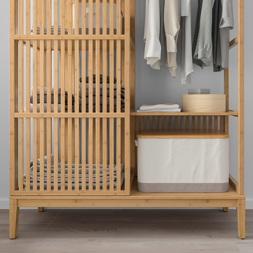 Armario de madera con puerta corredera, estantes y espacio para colgar ropa. También incluye contenedores de almacenamiento para organizar los artículos.