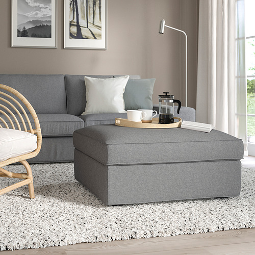 Reposapiés KIVIK gris en salón con almacenaje, complementa sofá azul.