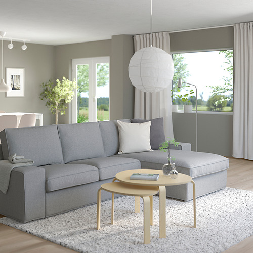 Salón moderno con sofá KIVIK, mesa de centro, lámpara colgante, ventana con cortinas.