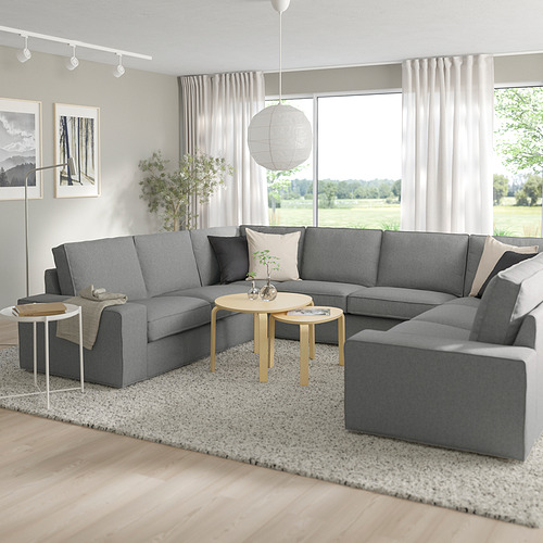 Moderno salón comedor con seccional KIVIK, mesas de madera, gran ventanal.
