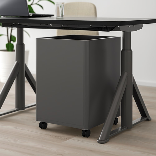 Cajonera debajo del escritorio negra con ruedas, parte de una configuración de oficina moderna.