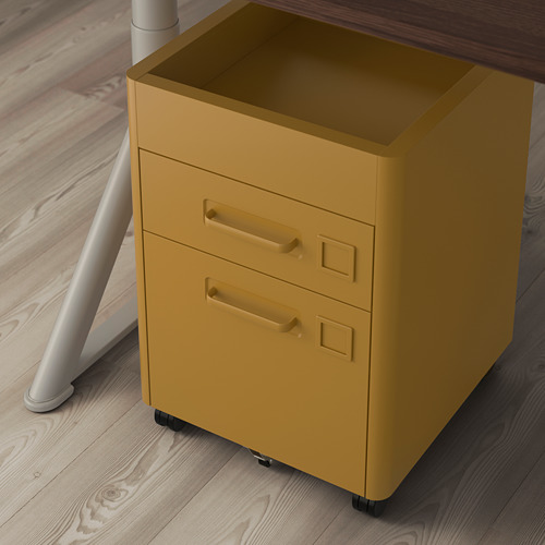 Archivador amarillo Ortiz con ruedas, apto para uso debajo del escritorio, colocado junto a un escritorio sobre un suelo de madera.
