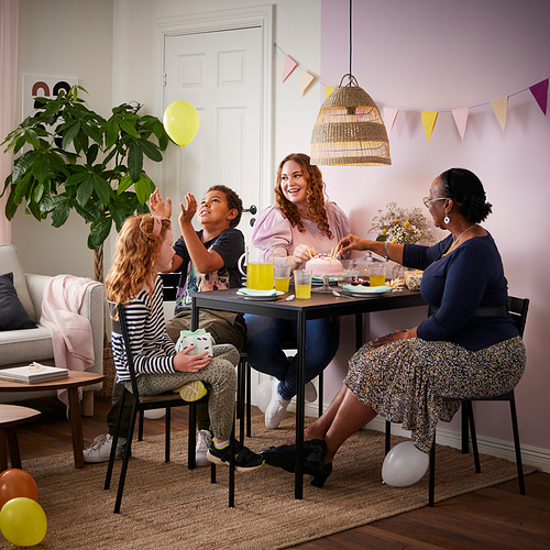 La familia de cinco disfruta de la fiesta de cumpleaños alrededor de la mesa de Sandberg con pastel y decoraciones.