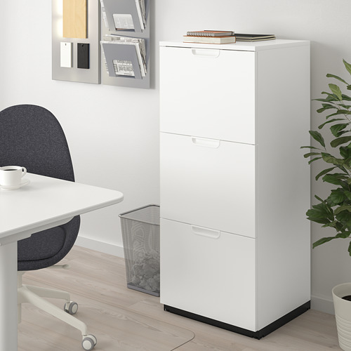 Armario de almacenamiento GALANT blanco con cerradura y patas ajustables, escritorio, silla azul, planta.