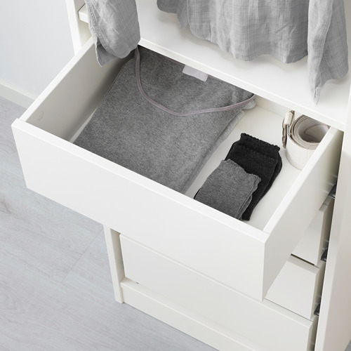 Un cajón blanco abierto de la serie KOMPLEMENT, con ropa doblada y una caja en su interior, diseñado para organizar objetos pequeños.
