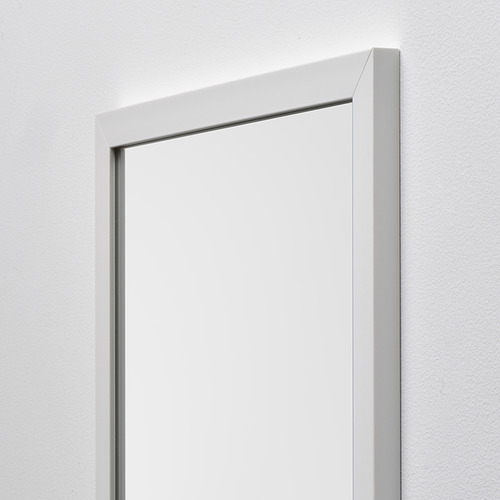 Un espejo con marco blanco cuelga de una pared clara, reflejando calidad y diseño moderno.