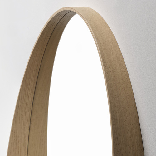 Espejo arqueado de madera con acabado en roble natural, estante curvo, montado en la pared.
