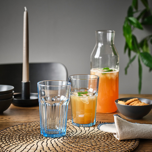 Mesa con vasos, jugo de naranja y galletas. Vidrio templado duradero.